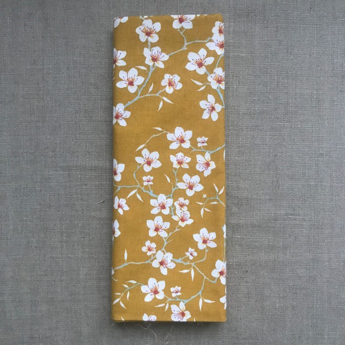 Coupon imprimé petites fleurs de pommiers blanches sur fond marron
