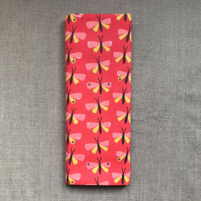 Coupon imprimé libellule rose et jaune sur fond rouge